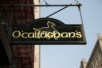 Image shows wooden hanging blade sign for O'Callaghan's Chicago,IL