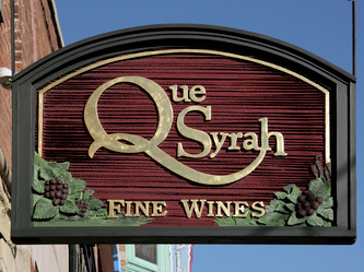 Image of The Wooden Sign Company's Que Syrah Blade Sign in Chicago,IL